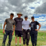 Four summer staff standing for photo during tree planting