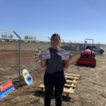 Summer student holding two new recreational trail signs