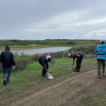 Four summer students picking garbage along recreational trail