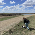 Summer student bending over to start wipper snipper