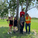 Group of summer students posting by tree for photo