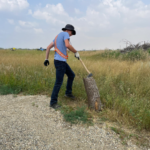 Summer student demonstrating how to use axe on piece of wood