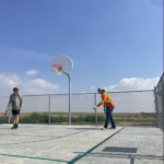 Two summer students playing pickleball on sport court during their lunch break